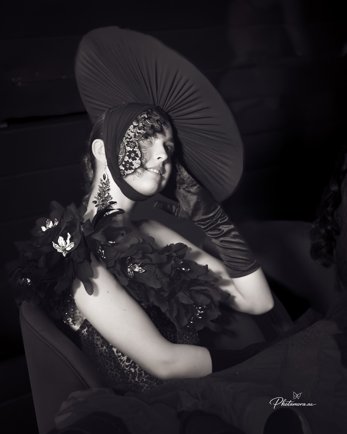 Black and white portrait of a model in a sculptural wide-brim hat